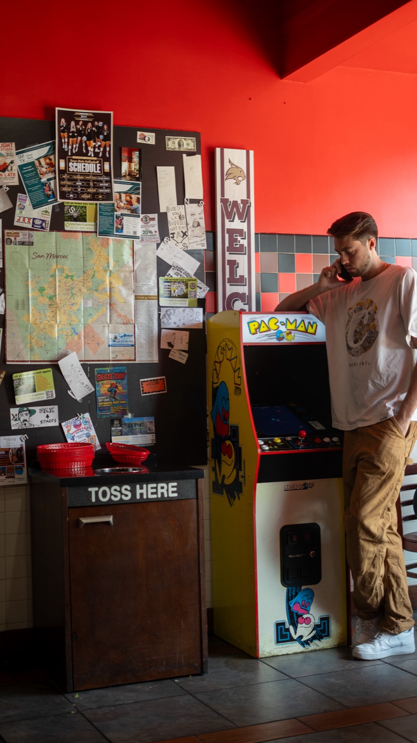 KY on the phone by a Pac-Man arcade machine